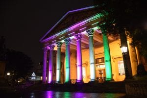 The Victoria Rooms lit up in suffragette colours